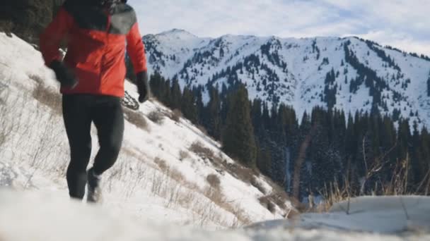 Muž běžící v horách se sněhem — Stock video
