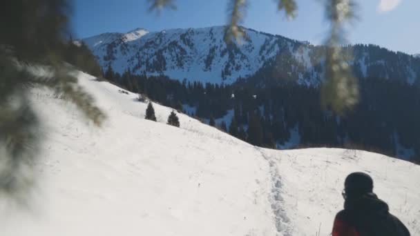 Człowiek biegnący po górach ze śniegiem — Wideo stockowe