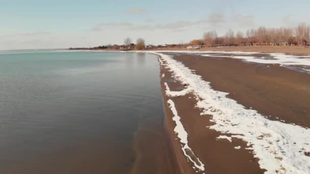 Vista aérea da praia com neve no lago — Vídeo de Stock