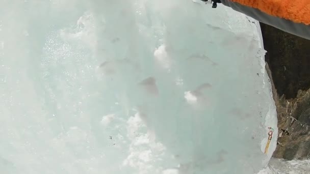 De mens beklimt de ijswaterval met touw en ijsbijl — Stockvideo