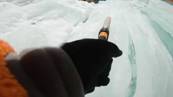 Mann klettert Eiswasserfall mit Seil und Eispickel — Stockvideo