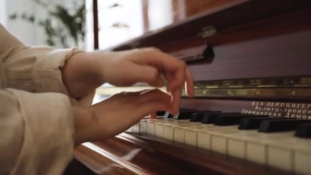 Жінка грає на старовинному дерев'яному піаніно — стокове відео