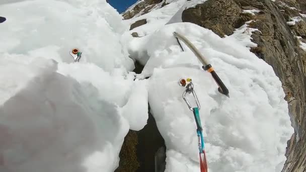 De mens beklimt de ijswaterval met touw en ijsbijl — Stockvideo