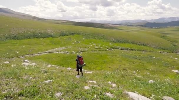 Wandelaar met grote rugzak in de bergen — Stockvideo