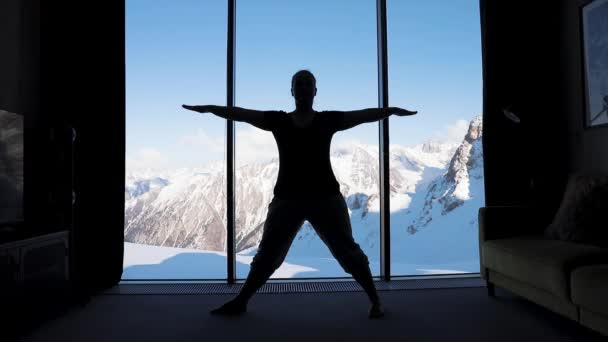 Практика йоги в комнате с видом на горы — стоковое видео