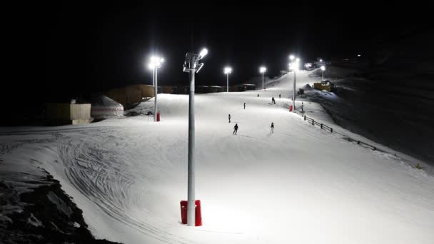 밤에 스키 리조트에서 타는 사람들. — 비디오