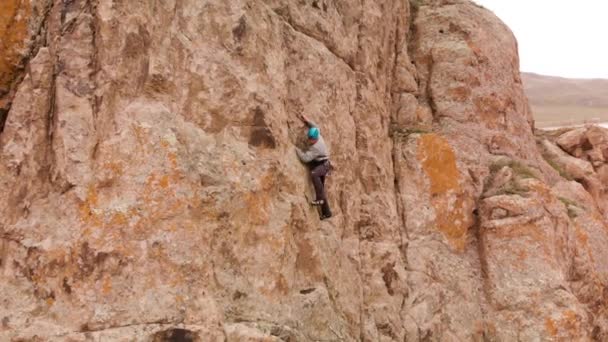 Mann klettert auf hohen Felsen — Stockvideo