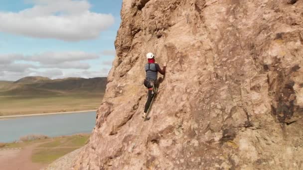 높은 바위 위로 기어오르는 사람 — 비디오