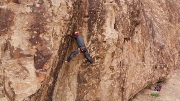 Férfi atléta mászik a magas sziklán — Stock videók
