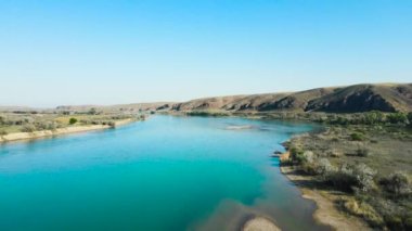 Kazakistan 'da gün batımında nehir ve dağların insansız hava aracı görüntüleri.