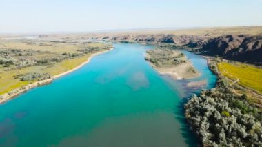 Kazakistan 'da gün batımında nehir ve dağların insansız hava aracı görüntüleri.