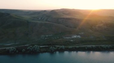 Kazakistan 'da gün batımında nehir ve dağların insansız hava aracı görüntüleri.