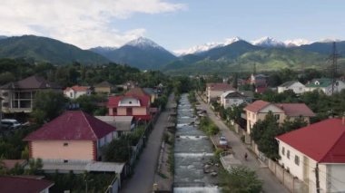 İnsanlı hava manzarası Almaty, Kazakistan 'da baharda evlerin ve dağların yanında bisiklet sürüyor.