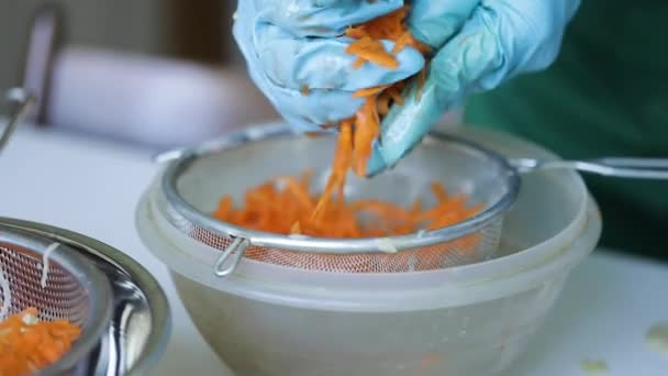 Frau Blauem Handschuh Ringt Geriebene Karotten Zum Kochen Aus — Stockvideo