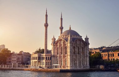 İstanbul 'da gün batımında kayıktan İstanbul Köprüsü ve Ortakoy Camii parlıyor