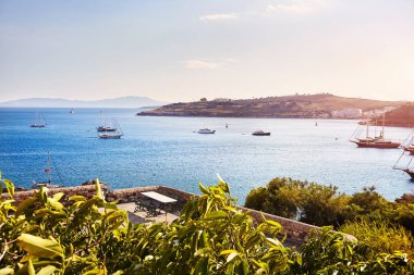 Kaleden Bodrum Sahili manzarası. Bodrum ilçesindeki tepelerde geleneksel beyaz evleri olan Ege Denizi 'nde yelkenli tekneler, yatlar