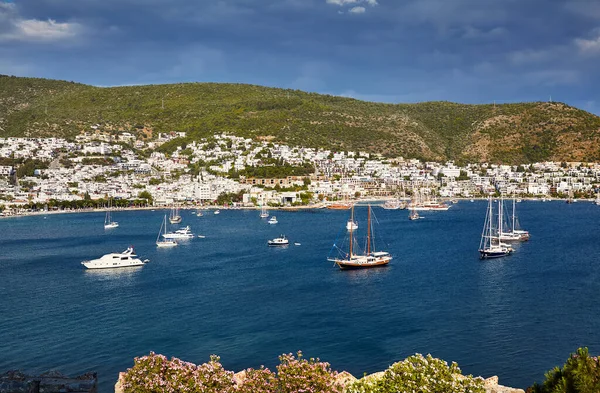 Kaleden Bodrum Sahili manzarası. Bodrum ilçesindeki tepelerde geleneksel beyaz evleri olan Ege Denizi 'nde yelkenli tekneler, yatlar