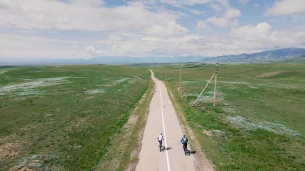 Pessoas Bicicletas Montanha Andam Estrada Asfalto Para Vale Montanha Contra — Vídeo de Stock