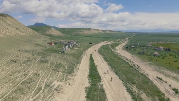 People Mountain Bikes Ride Country Road Mountain Valley Blue Cloudy — Stock video