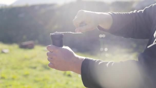 Man Slijpen Verse Koffiebonen Zwarte Grinder Klif Aan Het Meer — Stockvideo