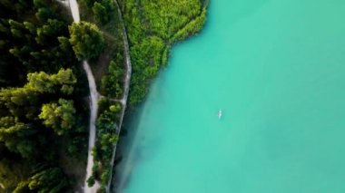 Top down aerial drone shot swim at stand up paddle boards SUP in the mountain lake Sairan in city Almaty in Kazakhstan.