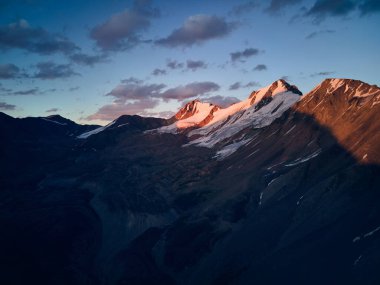 Dağların güzel manzarası. Mavi günbatımı gökyüzü Almatı, Kazakistan 'da kar buzullu siluet. Açık hava ve yürüyüş konsepti, insansız hava aracı görüntüsü.