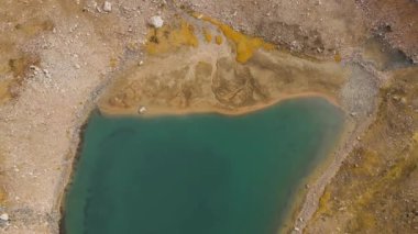 Almaty Kazakistan 'daki dağ vadisinde buzlu buzullu ve kayalık tepeli göl manzarası.