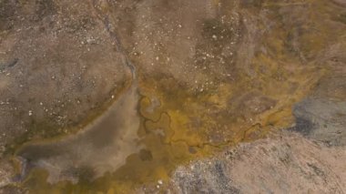 Almaty Kazakistan 'daki dağ vadisindeki kuru göl ve kahverengi kayalık tepelerin yukarıdaki hava aracı manzarası.