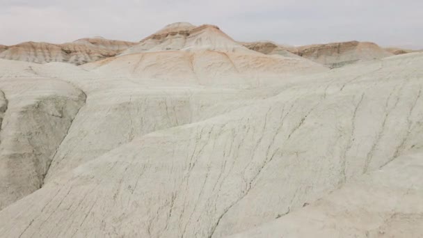 カザフスタン 中央アジアの干ばつの地球と渓谷と砂漠の超現実的な縞模様の白と黄色の山々の空中ドローンショット — ストック動画