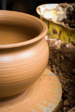 Bir çömlekçinin elleri, çemberin üzerinde toprak kavanozu yaratıyor.