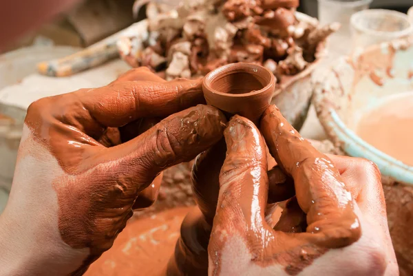 Hands of a potter, creating an earthen jar on the circle — Stock Photo, Image