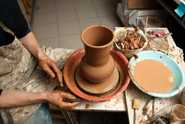 Hands of a potter, creating an earthen jar on the circle — Stock Photo, Image