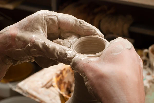 Hands of a potter, creating an earthen jar on the circle — Stock Photo, Image