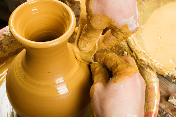 hands of a potter, creating an earthen jar