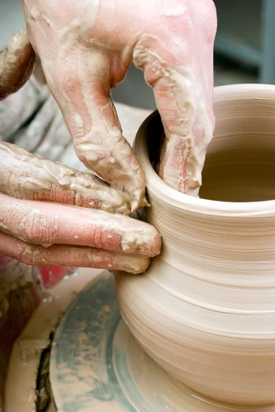 Hands of a potter, creating an earthen jar on the circle — Stock Photo, Image