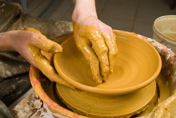 Handen van een pottenbakker, het creëren van een aarden pot op de cirkel — Stockfoto