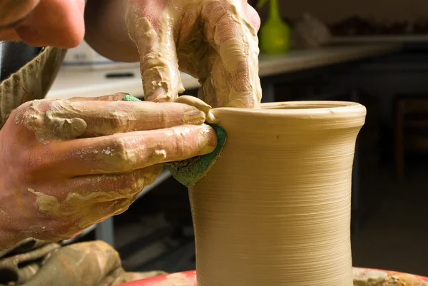 Handen van een pottenbakker, maken een aarden pot van witte klei — Stockfoto