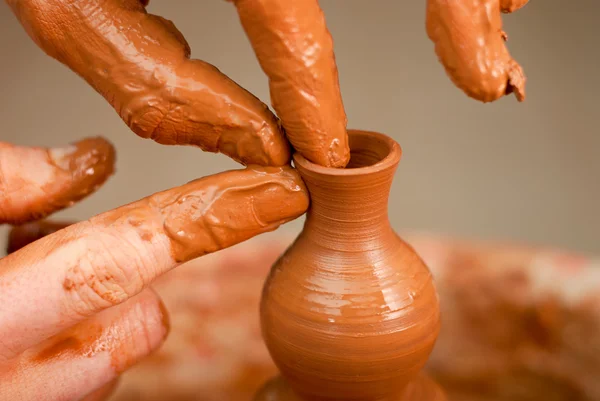 Handen van een pottenbakker, het creëren van een aarden pot op de cirkel — Stockfoto