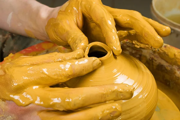 Hands of a potter, creating an earthen jar on the circle — Stock Photo, Image