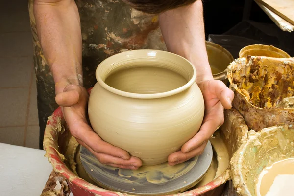 Handen van een pottenbakker, maken een aarden pot van witte klei — Stockfoto