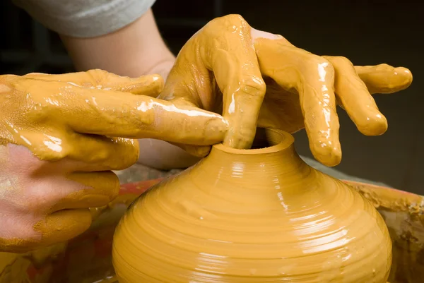 Handen van een pottenbakker, het creëren van een aarden pot op de cirkel — Stockfoto