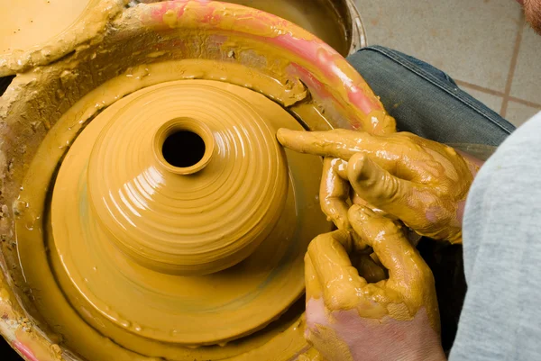 Handen van een pottenbakker, het creëren van een aarden pot op de cirkel — Stockfoto