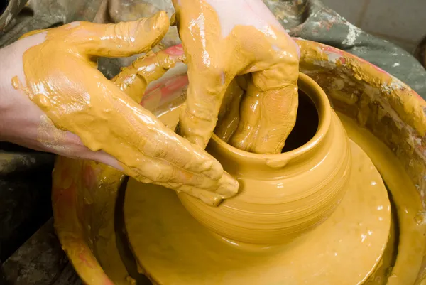 Hands of a potter, creating an earthen jar on the circle — Stock Photo, Image