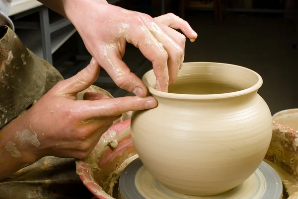 Hands of a potter, creating an earthen jar on the circle — Stock Photo, Image