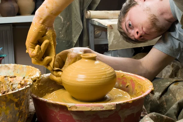 Hands of a potter, creating an earthen jar on the circle — Stock Photo, Image