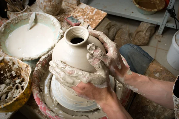 Handen van een pottenbakker, het creëren van een aarden pot op de cirkel — Stockfoto