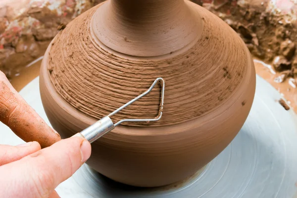 Hands of a potter, creating an earthen jar on the circle — Stock Photo, Image