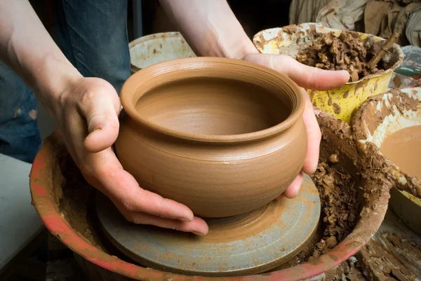 Hands of a potter, creating an earthen jar on the circle — Stock Photo, Image