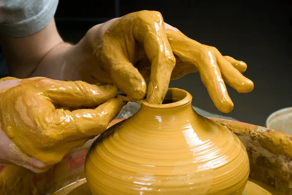 Hands of a potter, creating an earthen jar on the circle — Stock Photo, Image