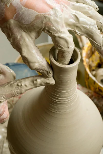 Hands of a potter, creating an earthen jar on the circle — Stock Photo, Image